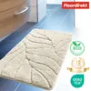 A bath mat with a leaf pattern is shown on a tiled floor next to a cabinet. Anteprima dell’immagine prodotto