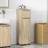 A bathroom cabinet and laundry basket in a tiled bathroom. Podgląd zdjęcia produktu