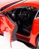 Close-up view of the interior of a red toy car, showing the steering wheel, dashboard, and open door. Produktbild-Vorschau