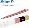 A rose gold Pelikan Jazz Noble pen is shown diagonally with a packaging box and color swatches below. Voir les images du produit