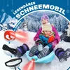 Two children are sitting on a blue sled in the snow, with a winter landscape in the background. There are also images of accessories like a rope and a handle. Produktbild-Vorschau