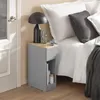 A bedside table next to a bed with pillows and a blanket. Produktbild-Vorschau