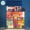 A lit-up dollhouse with furniture on a blue background. Voir les images du produit