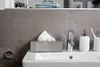 A bathroom sink with a tissue box, soap dispenser, faucet, and toothbrush holder. Anteprima dell’immagine prodotto