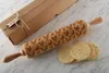 A wooden rolling pin with a chicken pattern and some cookies on a marble surface, next to a cardboard box. Voir les images du produit