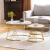 A set of two round coffee tables with marble-look tops and gold metal frames, placed on a rug in a living room setting. Náhľad obrázku produktu