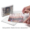 Two acrylic photo frames are shown, one with a dog and another with a wedding party. Hands are holding one of the frames. Produktbild-Vorschau