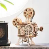 A wooden model of a film projector sits on a shelf next to a vintage clock. Produktbild-Vorschau