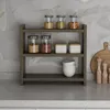 A three-tiered shelf unit holding various kitchen items like spice jars, bowls, and canisters, placed on a countertop with a marble-patterned backsplash. Anteprima dell’immagine prodotto