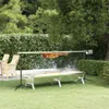 A rotisserie grill with meat cooking on it, set up on a grassy lawn in a garden setting. Produktbild-Vorschau