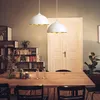 A dining room with a wooden table, chairs, and two pendant lights hanging above. Produktbild-Vorschau