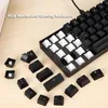 A close-up shot of a mechanical keyboard with some keys removed, scattered around it on a wooden surface. Podgląd zdjęcia produktu