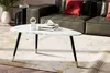 A modern living room scene with a coffee table in the foreground and a sofa in the background. Voir les images du produit