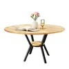 A round wooden dining table with a black metal base and a small shelf. Produktbild-Vorschau