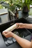 A person is rinsing a cleaning roller under a faucet in a kitchen sink. Produktbild-Vorschau