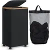 A black laundry basket with a wooden rim and lid, shown next to a black mesh laundry bag filled with clothes. Náhled obrázku produktu