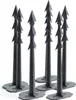 A group of black plastic ground anchors with harpoon-like tips and flat bases, arranged in a cluster against a white background. Náhled obrázku produktu