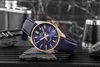 A watch is displayed on rocks with a dark, textured background. Voir les images du produit