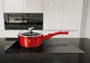 A red pot with a glass lid sits on a black induction stovetop in a modern kitchen. Náhled obrázku produktu