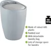 A light gray laundry hamper with a padded white seat, featuring text describing its features and a weight limit icon. Produktbild-Vorschau