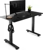 A black standing desk with a monitor, keyboard, mouse, lamp, and headphones. Produktbild-Vorschau