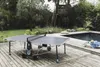 An outdoor ping pong table is set up on a wooden deck next to a swimming pool. Produktbild-Vorschau