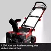 A red and black snow blower with LED lights illuminated. Produktbild-Vorschau