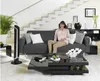 A woman sits on a couch in a modern living room with a tower fan next to her. Produktbild-Vorschau
