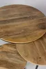 Close-up view of three round wooden tables with black metal frames, stacked. Voir les images du produit