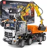 A detailed model of a remote-controlled construction truck, specifically an excavator and dump truck combination, is displayed against a neutral background. The packaging box for the toy is partially visible in the upper left corner. Voir les images du produit