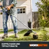 A person is using a string trimmer in a yard next to a house. Produktbild-Vorschau