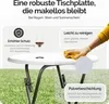 A white round table with dark gray legs is shown outdoors on green grass. Text overlays describe the table's features. Produktbild-Vorschau