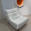 A beige sofa is placed in a room with a white wall and a circular orange light fixture. Anteprima dell’immagine prodotto