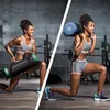 A woman performing lunges with a fitness bag in a gym setting. Produktbild-Vorschau