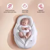 A baby is lying in a white baby nest with informational icons and text above. Anteprima dell’immagine prodotto