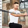 A man is performing a chest exercise using resistance bands attached to a squat rack. Náhľad obrázku produktu