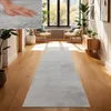 A hallway with a runner rug, chairs, and plants. Voir les images du produit