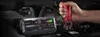 A hand is shown connecting jumper cables from a NOCO Boost Plus GB40 jump starter to a car battery under the hood of a vehicle. Podgląd zdjęcia produktu
