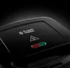 Close-up of the top of a black Russell Hobbs sandwich toaster, showing the brand logo and indicator lights. Produktbild-Vorschau