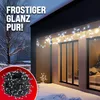 A winter scene with Christmas lights decorating the exterior of a house. Produktbild-Vorschau
