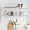 Two silver stainless steel wall shelves mounted on a white tiled wall, with various kitchen items displayed on them. Produktbild-Vorschau