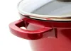 A close-up shot of the handle and rim of a red pot with a glass lid. Produktbild-Vorschau