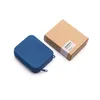 A blue silicone cutlery holder and a brown cardboard box are placed on a white background. Produktbild-Vorschau