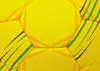 A close-up view of the textured surface of a yellow handball, showing the hexagonal panels and colored stripes. Anteprima dell’immagine prodotto