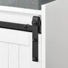 A close-up view of a white shoe cabinet with a black sliding door mechanism and a gray upholstered seat. Náhľad obrázku produktu