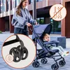 A woman pushing a baby stroller on a sidewalk. Produktbild-Vorschau