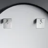 Two metal mounting brackets are attached to a light gray wall, with a black curved frame visible at the top. Náhľad obrázku produktu