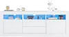 A white TV stand with LED lighting and decorative items on top. Produktbild-Vorschau