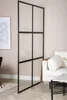 A room divider is placed in a living room setting next to a sofa and a coffee table. Produktbild-Vorschau