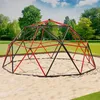 A dome-shaped climbing frame for children is set up in a sandy area in a park or backyard, surrounded by green grass and trees under a partly cloudy sky. Náhled obrázku produktu